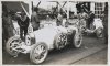 Fotografía del piloto  Pedro de Vizcaya con su bólido Bugatti en el II Gran Premio de San Sebastián. Detrás, el piloto Bartolomeno Costantini con su bólido Bugatti. De pie, con las manos en los bolsillos, el piloto Giulio Foresti