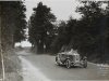 Fotografía de Louis Rigal, piloto participante en el III Gran Premio de Turismos. Detrás, Louis Rigal con su automóvil peugeot