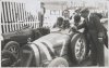 Fotografía del piloto Louis Chirón sobre su automóvil Bugatti y su escuadra alrededor