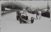 Fotografía del campeon de 1928, 1929 y 1933 Louis Chirón sobre su automóvil Alfa Romeo en el circiuto de Lasarte bajo la atenta mirada del público