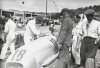 Fotografía del piloto campeón de 1934 Luigi Fagioli sobre su automóvil conversando con unos mecánicos