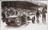 Fotografía de los pilotos Tazio Nuvolari y Jean Pierre Wimille se dirigen a sus vehículos mientras dos mecánicos empujan el automóvil Bugatti de Tazio Nuvolari