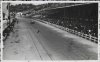 Fotografía de aficionados de las tribunas y mecánicos de los boxes observando a un automóvil que compite en el Gran Premio de España de 1935