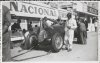 Fotografía del piloto Tazio Nuvolaro observando su automóvil Alfa Romeo