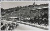 Fotografía de los organizadores y periodistas en la pista del circuto Lasarte bajo la atenta mirada del público de las tribunas y las laderas